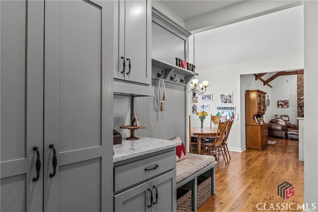 1233 Staplers Bridge Rd, Nicholson, GA 30565 - kitchen with gray cabinets, light wood-style floors, a chandelier, light stone counters, and open shelves