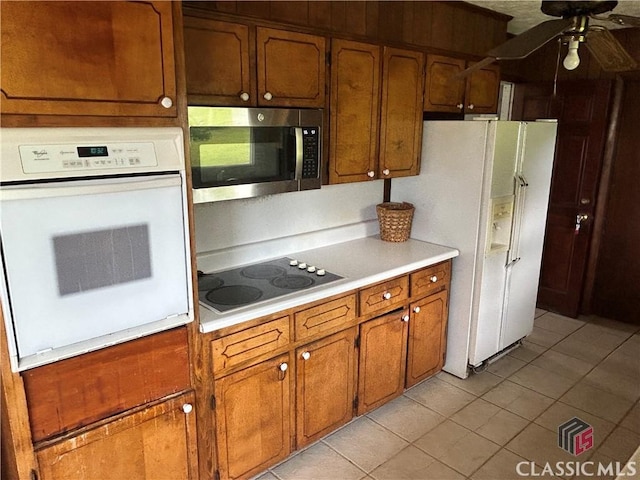220 Swanson Dr W Unit 1, Athens, GA 30606 - kitchen featuring white appliances, a ceiling fan, brown cabinets, light tile patterned floors, and light countertops