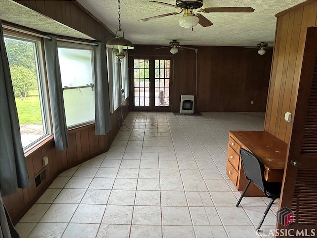 220 Swanson Dr W Unit 1, Athens, GA 30606 - unfurnished sunroom with heating unit, a textured ceiling, wooden walls, a wood stove, and french doors