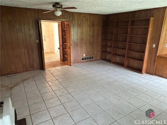 220 Swanson Dr W Unit 1, Athens, GA 30606 - empty room featuring a textured ceiling, wood walls, ceiling fan, and light tile patterned floors