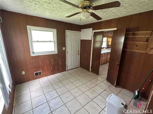 220 Swanson Dr W Unit 1, Athens, GA 30606 - spare room featuring wooden walls, ceiling fan, light tile patterned floors, and a textured ceiling