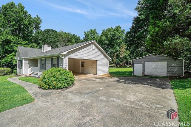 148 Hunters Crossing Rd, Athens, GA 30606 - view of front of house with an outbuilding, a front yard, a chimney, a detached garage, and a shingled roof