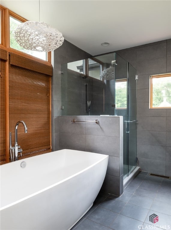 497 W Rutherford St, Athens, GA 30606 - bathroom with tile patterned flooring, a stall shower, a freestanding bath, and tile walls