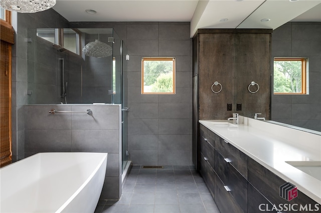 497 W Rutherford St, Athens, GA 30606 - bathroom featuring tile walls, tile patterned floors, a stall shower, a freestanding bath, and double vanity