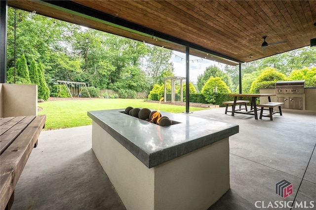 497 W Rutherford St, Athens, GA 30606 - fenced backyard with a playground, exterior kitchen, a patio, a ceiling fan, and view of scattered trees