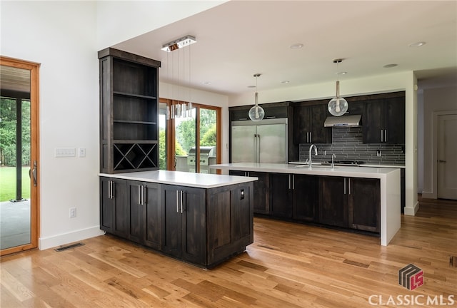 497 W Rutherford St, Athens, GA 30606 - kitchen featuring built in fridge, under cabinet range hood, light countertops, open shelves, and light wood finished floors