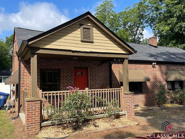 49 New St E, Winder, GA 30680 - view of front of home with brick siding, covered porch, and a chimney