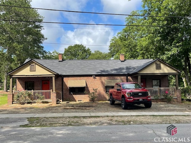 49 New St E, Winder, GA 30680 - view of front of home with a porch, brick siding, driveway, and a chimney