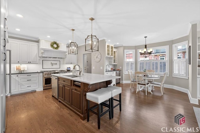 1232 Everton Pl, Cumming, GA 30041 - kitchen featuring a chandelier, stainless steel appliances, dark wood-style floors, a breakfast bar area, and crown molding