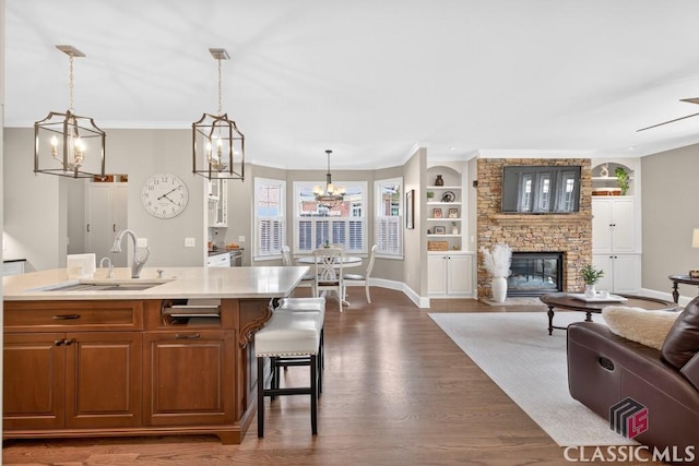 1232 Everton Pl, Cumming, GA 30041 - kitchen with a chandelier, crown molding, a fireplace, open floor plan, and light countertops