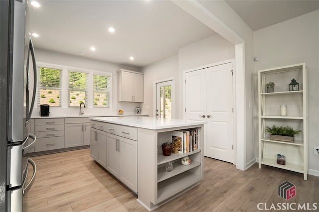 1260 Starboard Way, Greensboro, GA 30642 - kitchen featuring freestanding refrigerator, open shelves, light wood finished floors, a kitchen island, and light countertops
