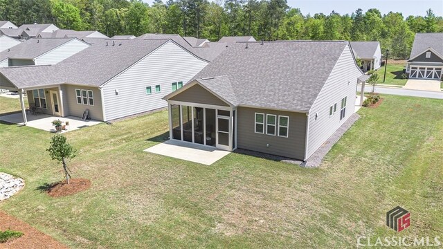 1260 Starboard Way, Greensboro, GA 30642 - rear view of house featuring a sunroom, a patio area, roof with shingles, and a yard