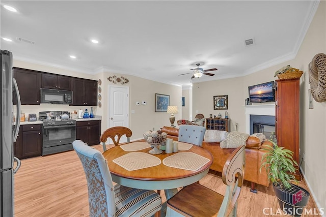 263 Turtle Creek Dr, Winder, GA 30680 - dining area featuring light wood-type flooring, ornamental molding, ceiling fan, recessed lighting, and a glass covered fireplace