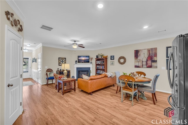263 Turtle Creek Dr, Winder, GA 30680 - living room featuring crown molding, ceiling fan, light wood-style floors, a glass covered fireplace, and recessed lighting