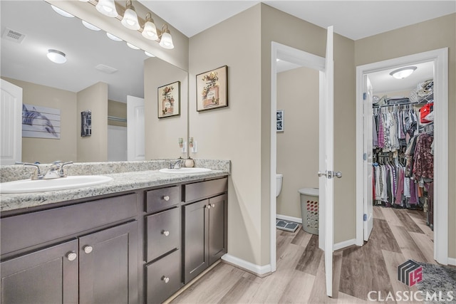 263 Turtle Creek Dr, Winder, GA 30680 - bathroom featuring wood finished floors, double vanity, and a walk in closet