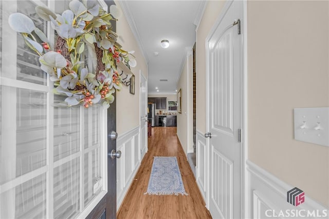 263 Turtle Creek Dr, Winder, GA 30680 - hall with light wood finished floors, wainscoting, ornamental molding, and a decorative wall