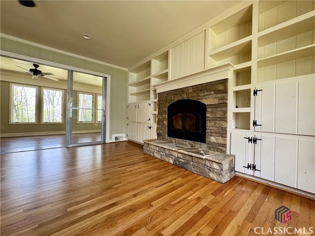 270 Riverhill Dr, Athens, GA 30606 - unfurnished living room with ornamental molding, built in shelves, light wood-style flooring, ceiling fan, and a stone fireplace