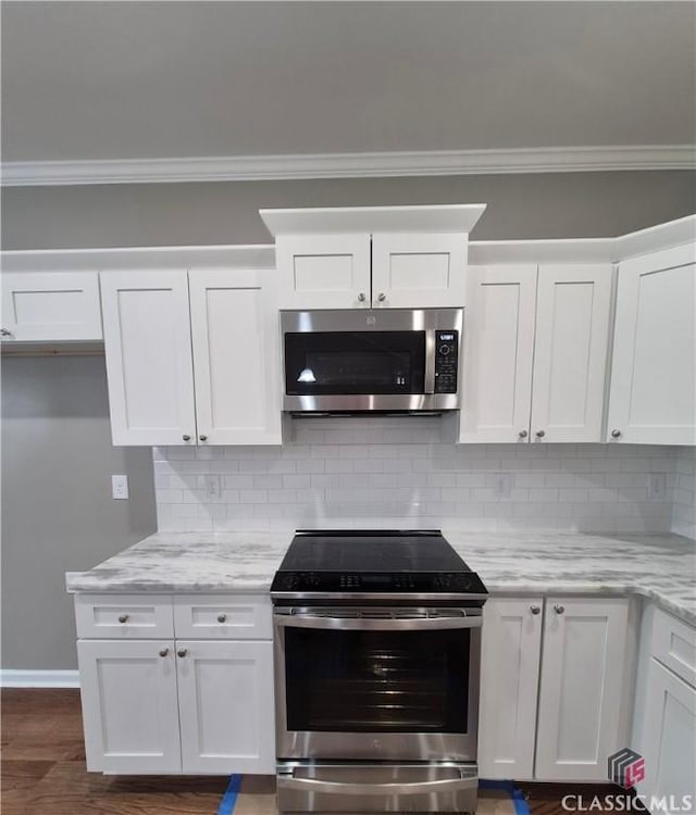 1090 Fox Glen Dr, Watkinsville, GA 30677 - kitchen with appliances with stainless steel finishes, crown molding, white cabinets, and backsplash