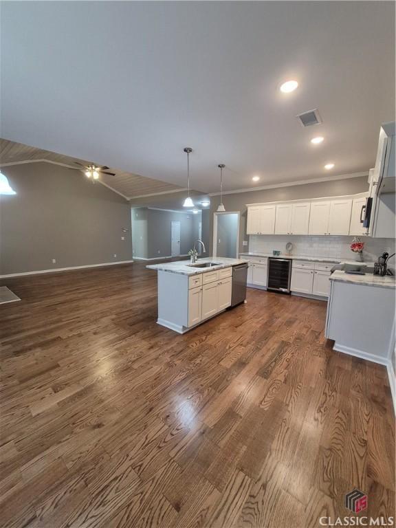 1070 Lane Creek Ter, Bishop, GA 30621 - kitchen with beverage cooler, open floor plan, white cabinetry, a center island with sink, and light countertops