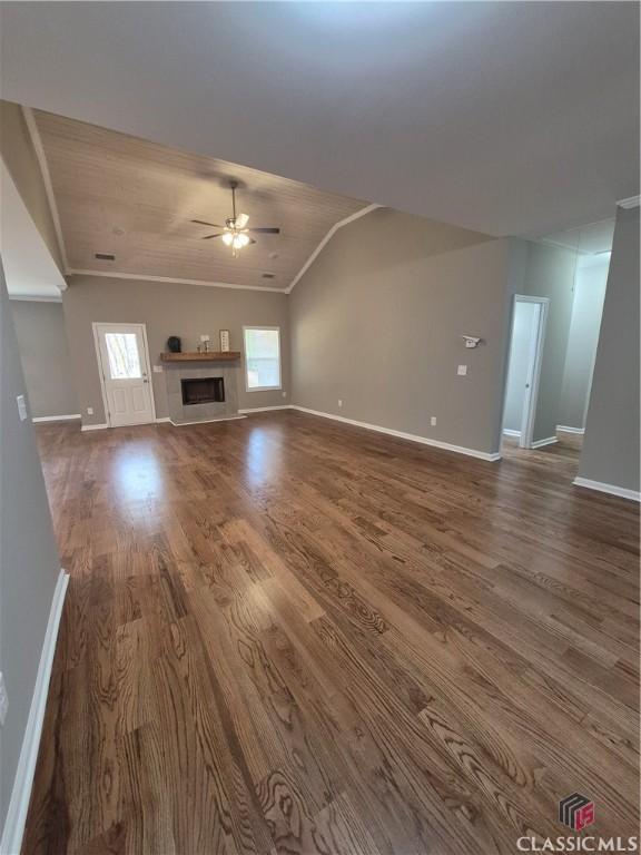 1070 Lane Creek Ter, Bishop, GA 30621 - unfurnished living room with wooden ceiling, dark wood-style floors, a tile fireplace, crown molding, and a ceiling fan