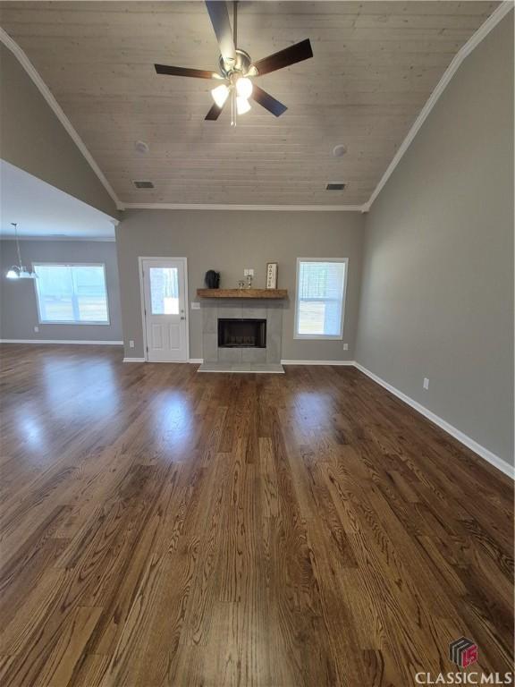 1070 Lane Creek Ter, Bishop, GA 30621 - unfurnished living room with wood ceiling, dark wood-style flooring, a tiled fireplace, ornamental molding, and a ceiling fan