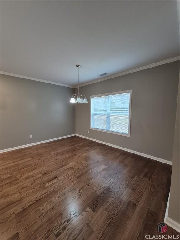 1070 Lane Creek Ter, Bishop, GA 30621 - empty room with a chandelier, dark wood-style floors, and crown molding