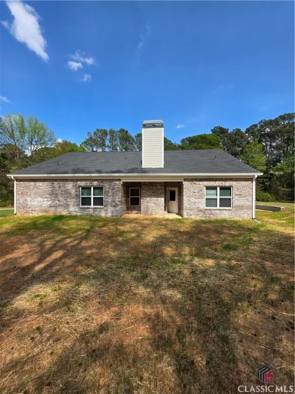 1070 Lane Creek Ter, Bishop, GA 30621 - back of property with a chimney, a lawn, and brick siding