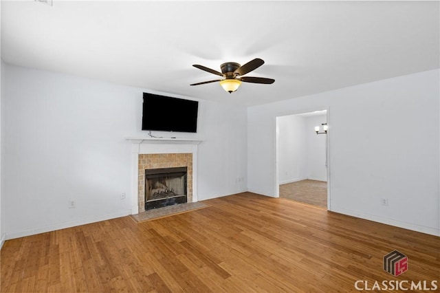 255 Twin Creek Shrs, Athens, GA 30605 - unfurnished living room with a tiled fireplace, ceiling fan, and light wood-style flooring