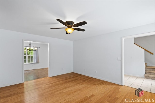 255 Twin Creek Shrs, Athens, GA 30605 - unfurnished room with a chandelier, stairway, a ceiling fan, and light wood-style flooring