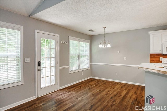 94 Pinewood Cir, Colbert, GA 30628 - unfurnished dining area with a chandelier, dark wood finished floors, and a textured ceiling