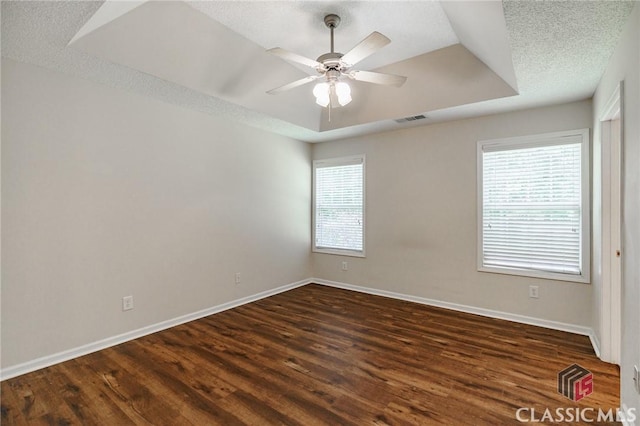 94 Pinewood Cir, Colbert, GA 30628 - empty room with a raised ceiling, dark wood-style floors, and a ceiling fan