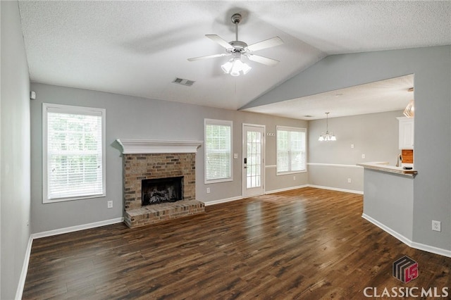 94 Pinewood Cir, Colbert, GA 30628 - unfurnished living room featuring a brick fireplace, dark wood-style flooring, vaulted ceiling, ceiling fan, and plenty of natural light