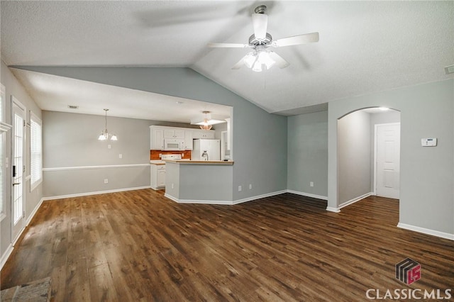 94 Pinewood Cir, Colbert, GA 30628 - unfurnished living room featuring arched walkways, ceiling fan, dark wood finished floors, lofted ceiling, and a textured ceiling