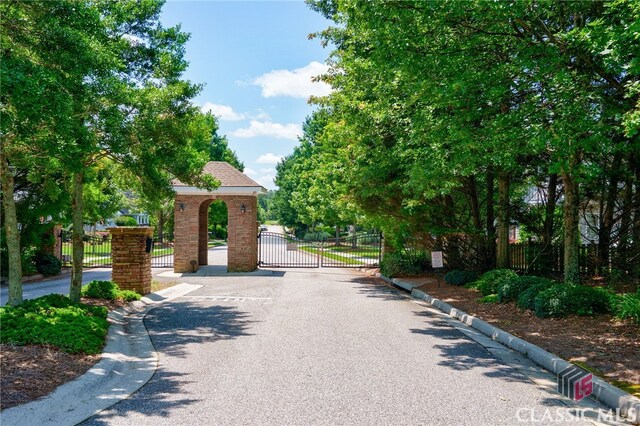 1640 Madison Ct, Bogart, GA 30622 - view of asphalt street featuring curbs, a gate, and a gated entry
