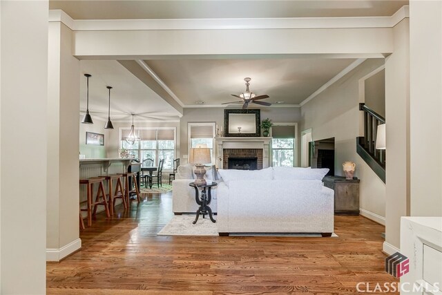 1640 Madison Ct, Bogart, GA 30622 - living room featuring a ceiling fan, plenty of natural light, wood finished floors, a fireplace, and crown molding