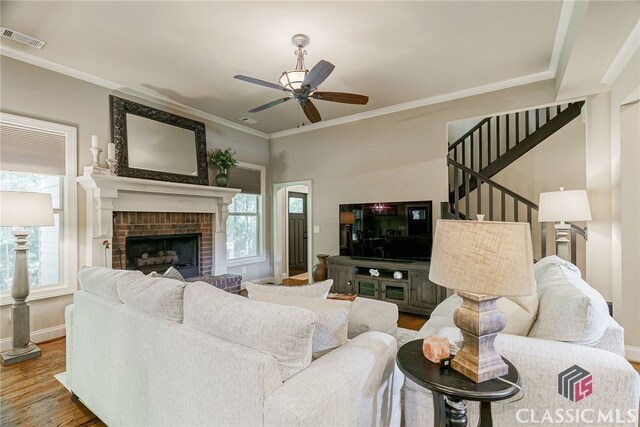 1640 Madison Ct, Bogart, GA 30622 - living area featuring wood finished floors, a ceiling fan, stairs, a fireplace, and crown molding