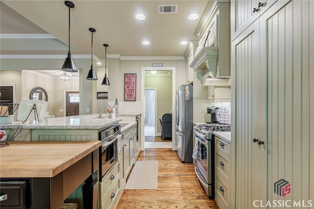 1640 Madison Ct, Bogart, GA 30622 - kitchen featuring stainless steel appliances, butcher block countertops, crown molding, light wood-style flooring, and pendant lighting