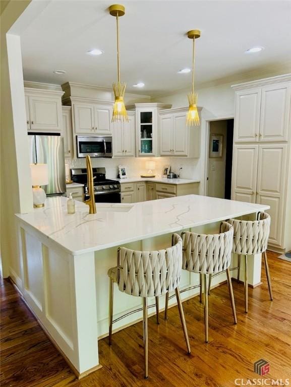 1105 Harperfield Dr, Bogart, GA 30622 - kitchen featuring stainless steel appliances, a breakfast bar, decorative light fixtures, white cabinetry, and dark wood-style floors