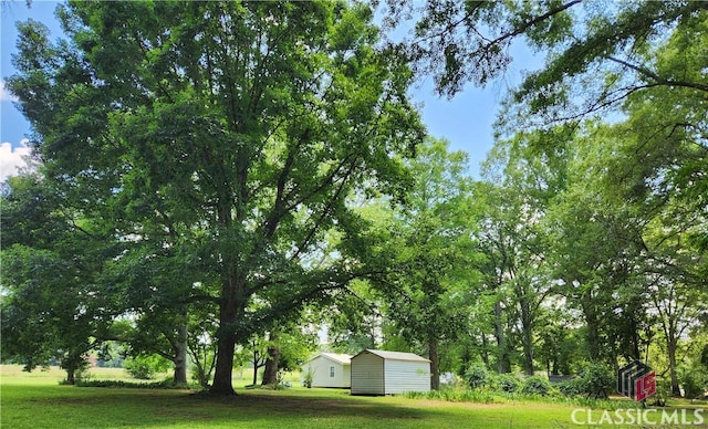 4660 Fairplay Rd, Madison, GA 30650 - view of green lawn with a storage shed