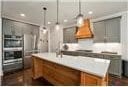 1069 Dean Hill Rd, Monroe, GA 30655 - kitchen featuring brown cabinetry, decorative light fixtures, light countertops, and a center island with sink