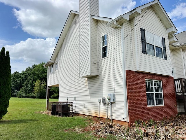 view of property exterior with central air condition unit and a lawn