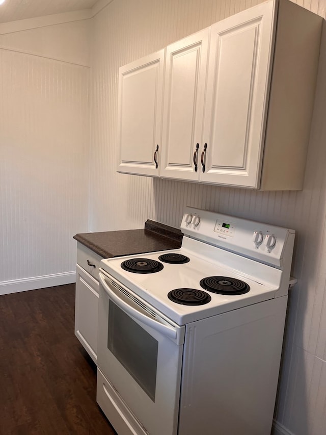 kitchen with dark wood finished floors, white cabinetry, dark countertops, and white electric range oven