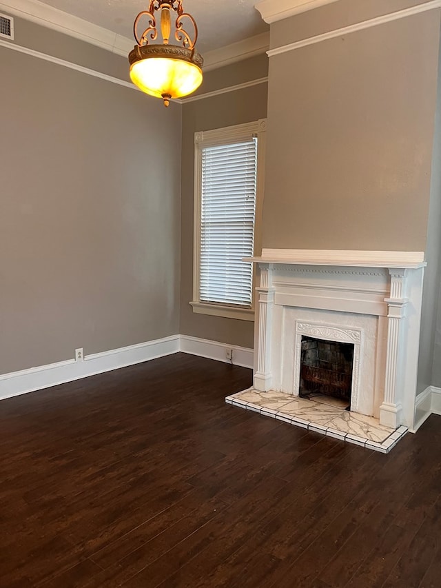 unfurnished living room featuring visible vents, baseboards, a premium fireplace, dark wood finished floors, and crown molding