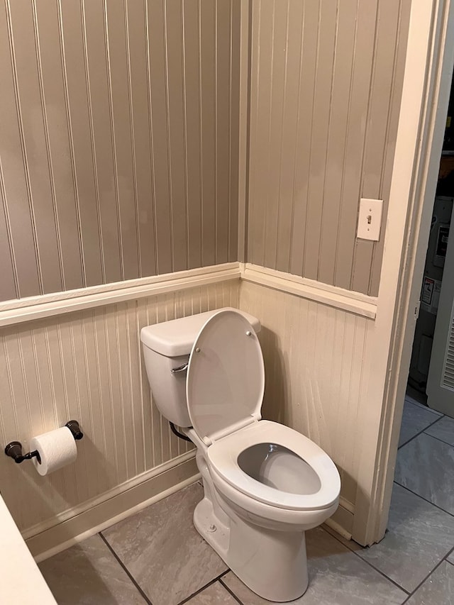 bathroom with tile patterned floors, baseboards, and toilet