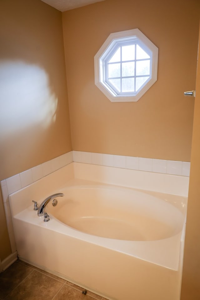 full bath featuring a bath and tile patterned floors