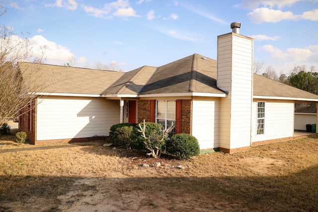 exterior space with a chimney and brick siding