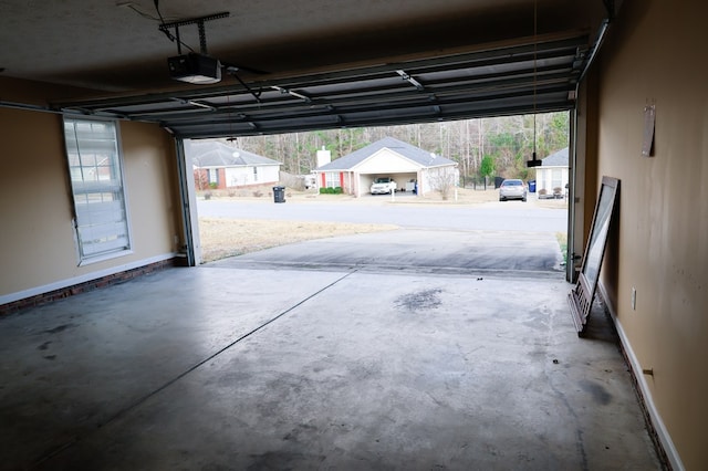 garage with baseboards and a garage door opener