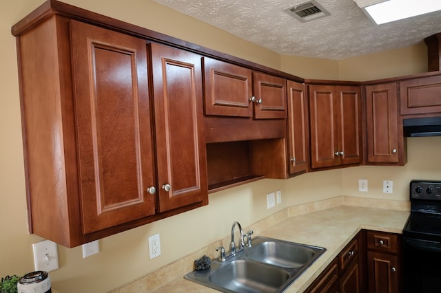 kitchen featuring a textured ceiling, a sink, visible vents, light countertops, and black electric range oven