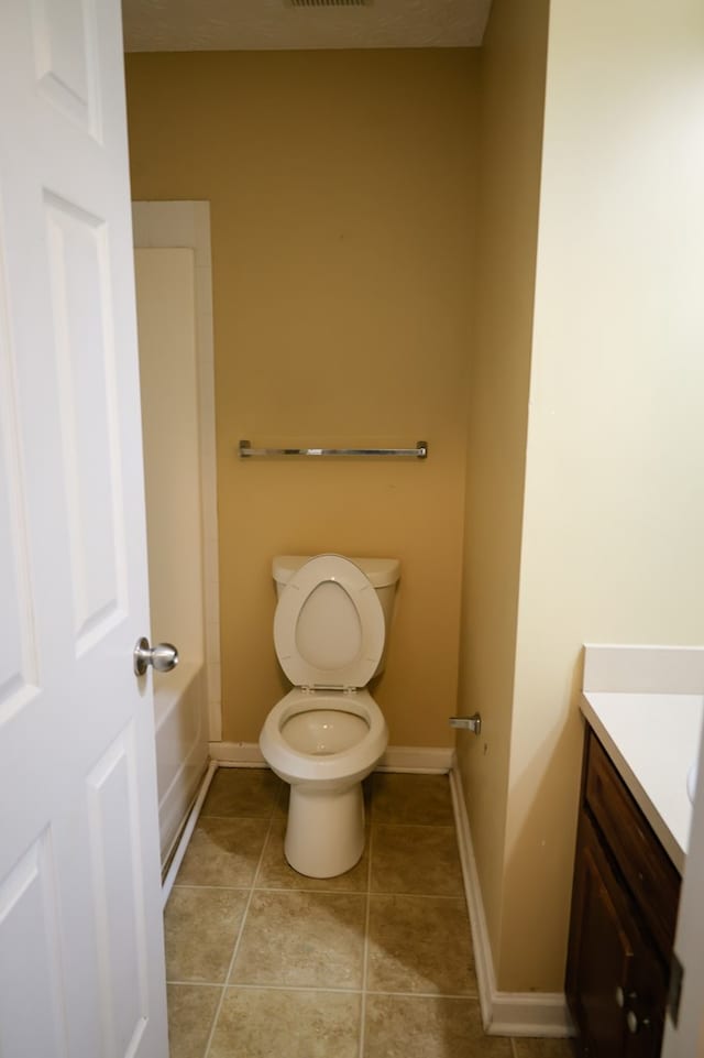 bathroom featuring toilet, vanity, baseboards, and tile patterned floors