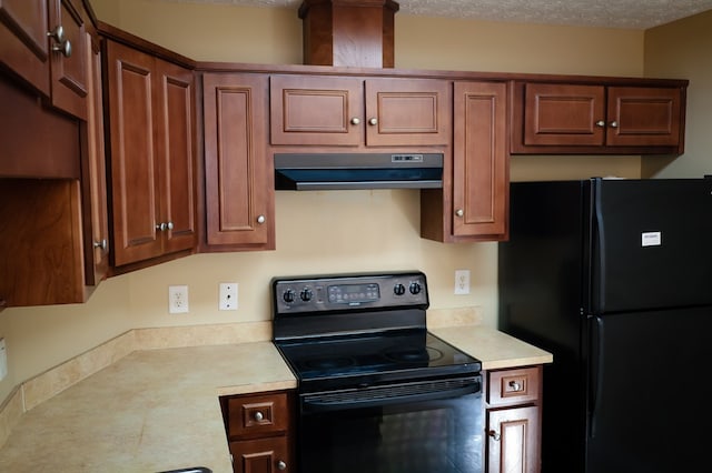 kitchen featuring brown cabinets, light countertops, a textured ceiling, under cabinet range hood, and black appliances